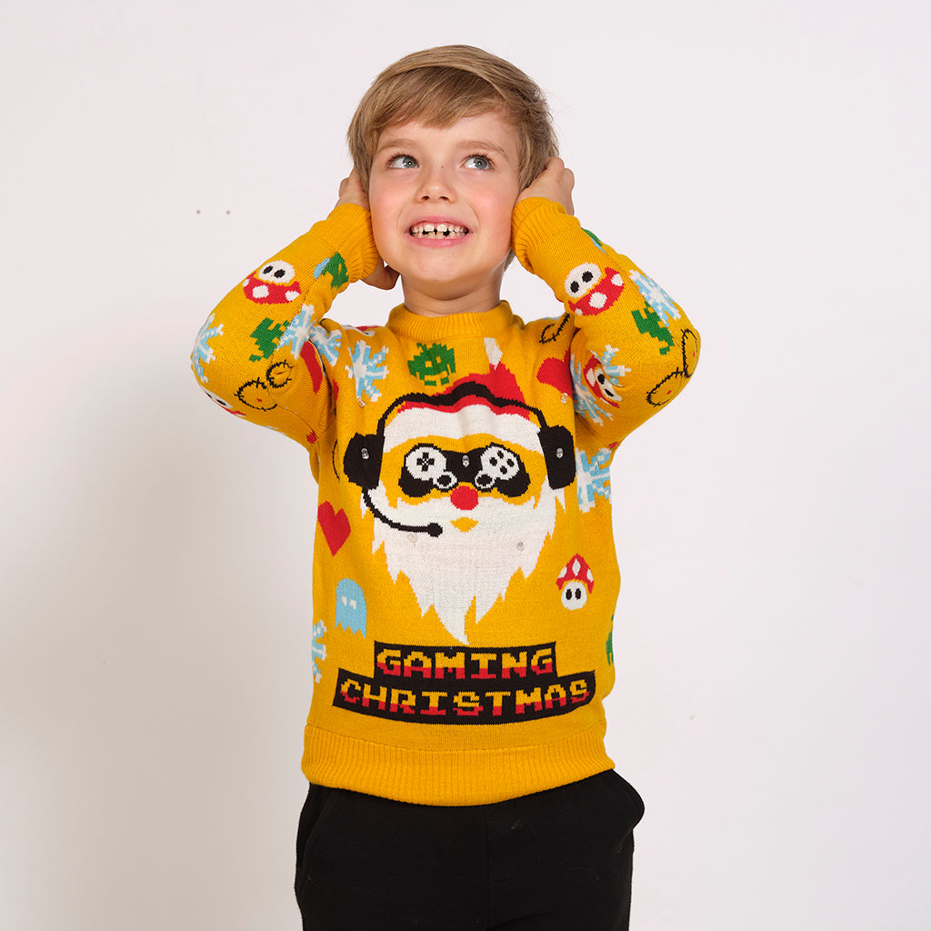 Ett barn som bär en gul jultröja med en gamer-tomte och lampor på.